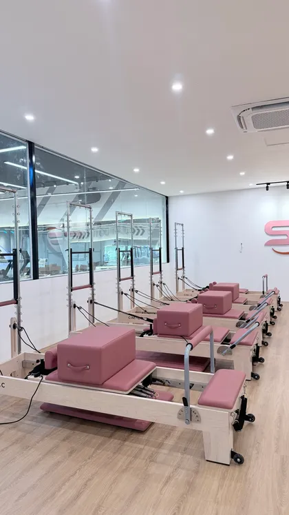 Dãy Reformer nhìn từ cuối phòng — máy Pilates Cimac khung gỗ Maple